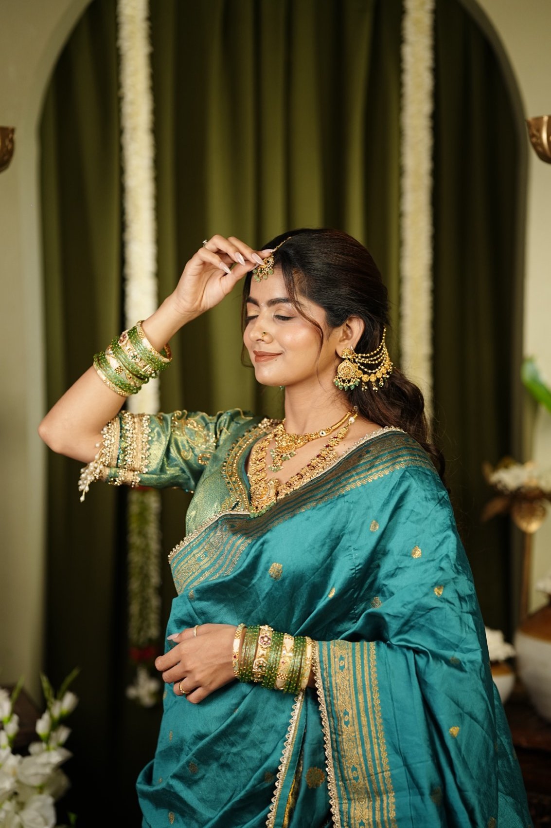 Anushka Sonawane in a teal silk saree with traditional gold jewellery